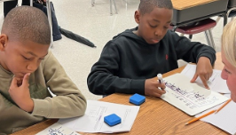  Young boys in school focusing on their school work.